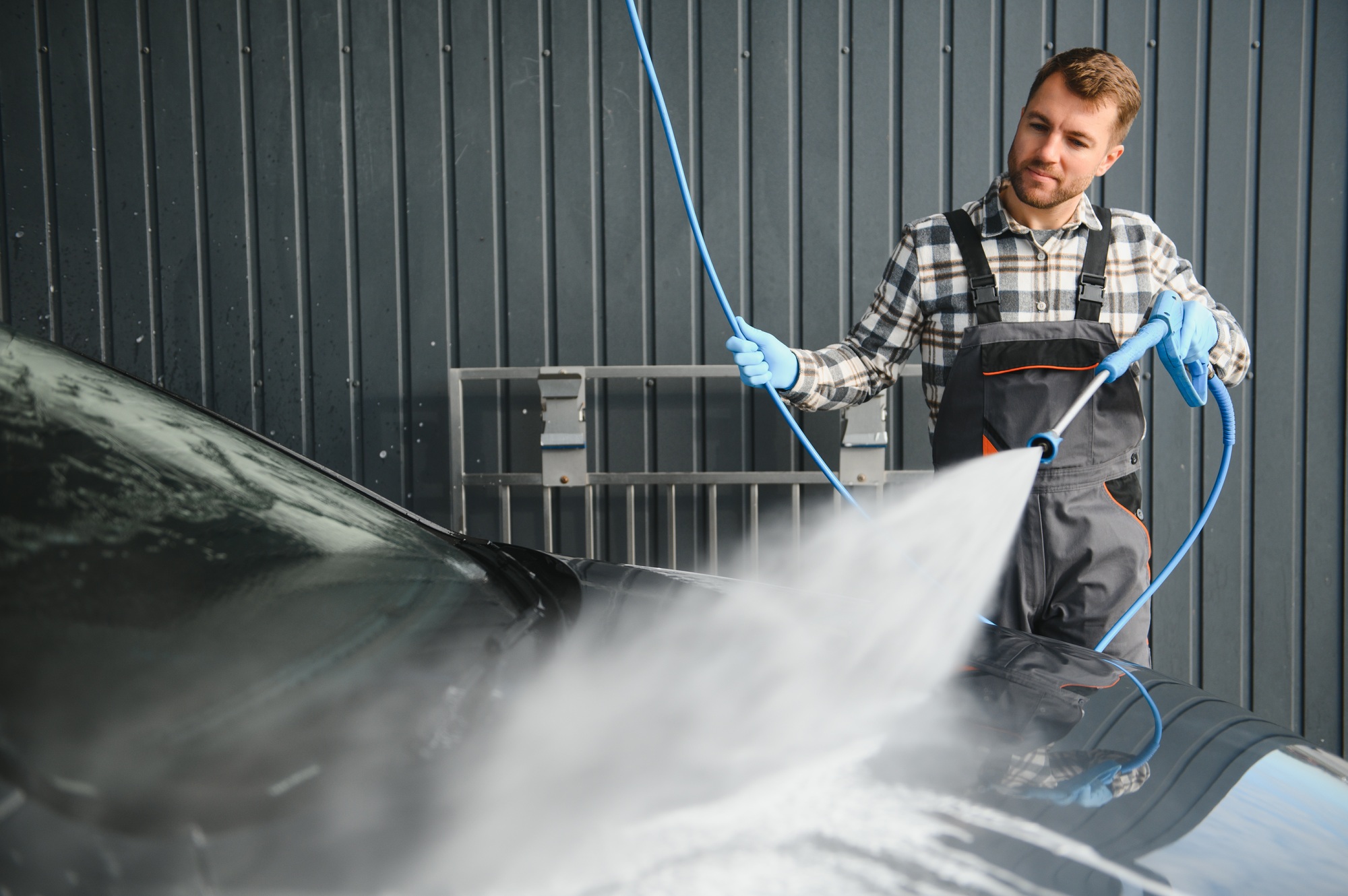 Car Wash Specialist Using Pressure Washer to Rinse a car